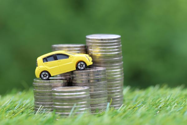 Yellow car driving up silver coins